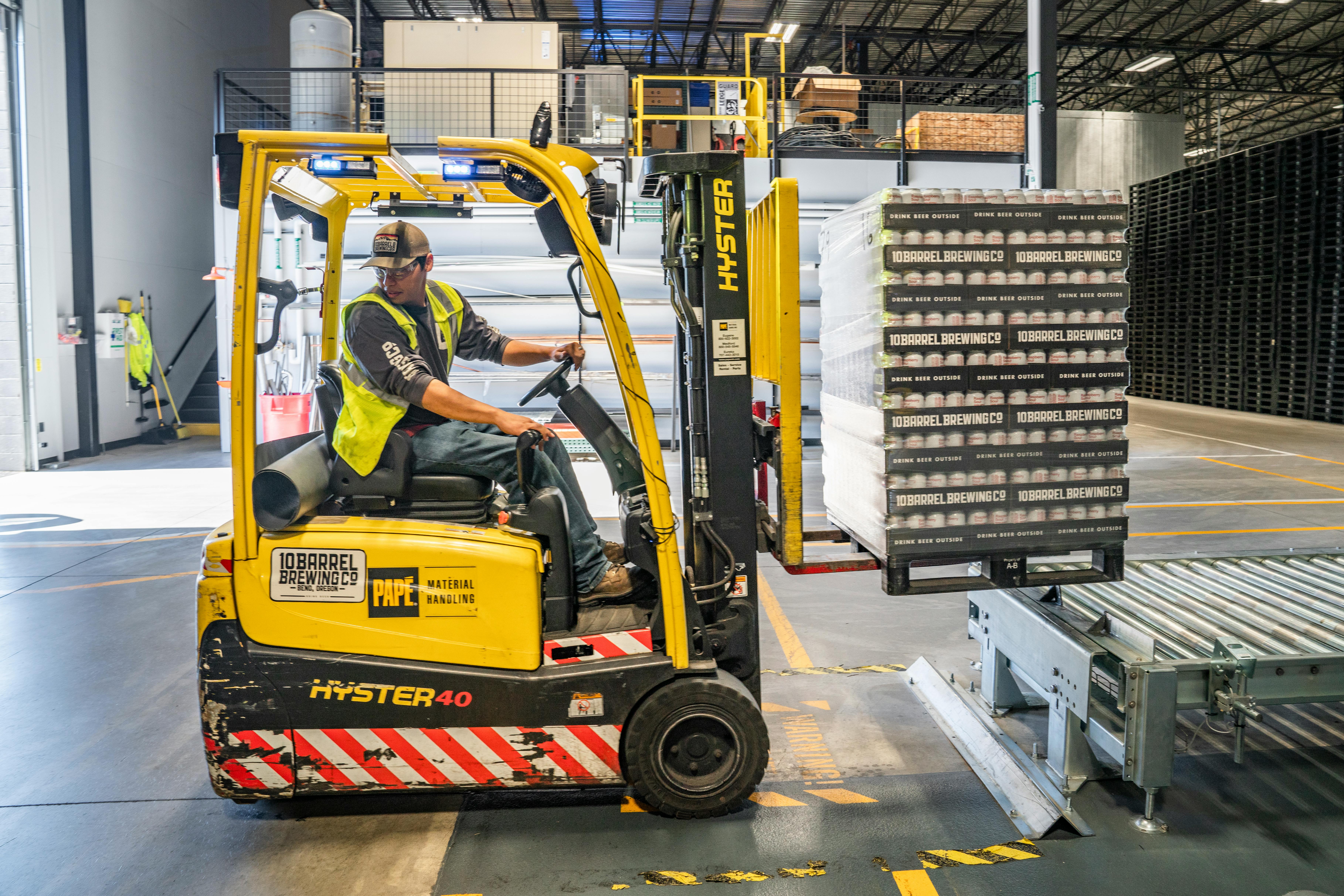 A person in a warehouse using a forklift.